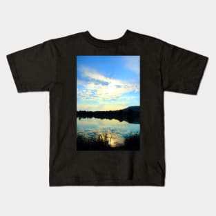 Mystical view with vegetation in the foreground, indistinct waters, Marche hills and azure sky Kids T-Shirt